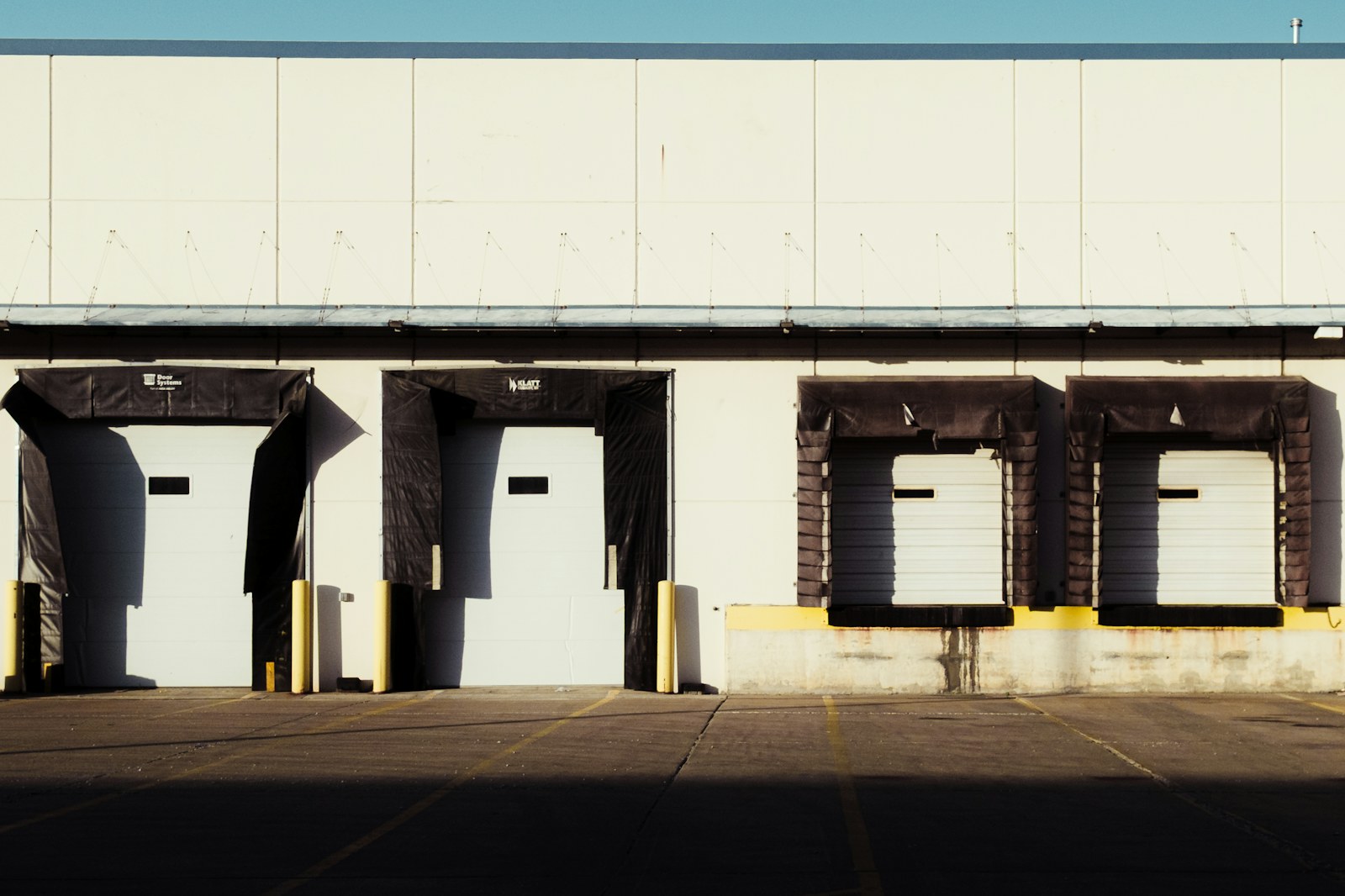 Row of warehouse loading dock doors with an empty apron, the position where a delivered storage trailer gets spotted