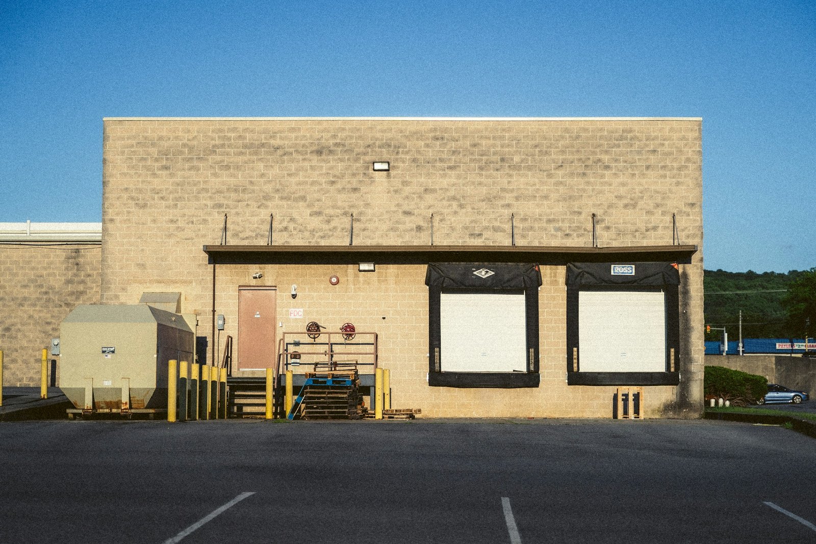 Two dock doors on a small Ohio plant with pallets stacked beside the steps, the kind of building where RMA Fleet customers choose between same-day local trucking and a storage trailer rental